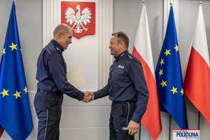 I Zastępca Komendanta Głównego Policji ściska dłoń funkcjonariuszowi gratulując.