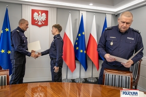 I Zastępca Komendanta Głównego Policji ściska dłoń funkcjonariuszowi gratulując.