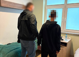 policjant stoi z zatrzymanym.
