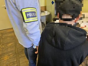 Funkcjonariusz policji z zatrzymanym mężczyzną.
