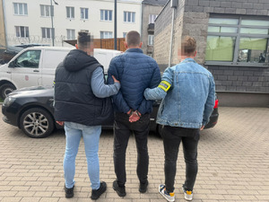 Policjanci prowadzą zatrzymanego.