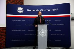 policjant stoi na mównicy.