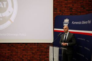 policjant stoi na mównicy.