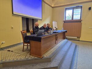 policjanci siedzą na podwyższeniu.