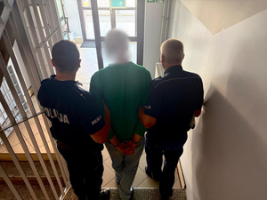 Policjanci prowadzą zatrzymanego.