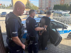 Policjanci prowadzą zatrzymanego.