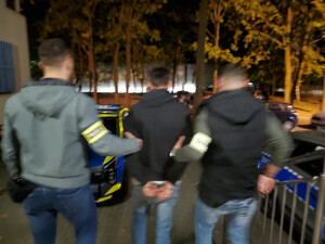 Policjanci prowadzą zatrzymanego.
