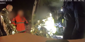 Policjanci i ratownik medyczny, który udziela pomocy mężczyźnie.