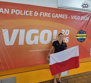 Kobieta w stroju sportowym z flagą Polski.