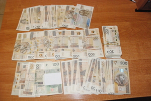 Banknoty pieniędzy leżą rozłożone na blacie.