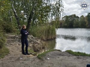 Policjantka stoi przy zbiorniku wodnym.