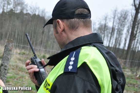 policjant podaje komunikat przez radiostację