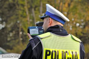 Policjant ruchu drogowego kontroluje prędkość jadących pojazdów.