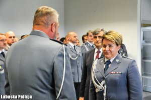 Złożenie meldunku przez dowódcę uroczystości - w tle stojący policjanci w szeregu.