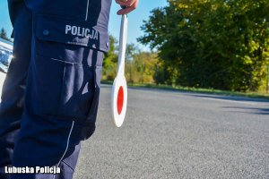 Tarcza do zatrzymywania pojazdów przy spodniach od munduru policjanta.