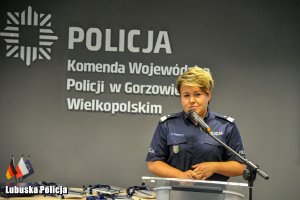 Policjantka przemawia do mikrofonu.