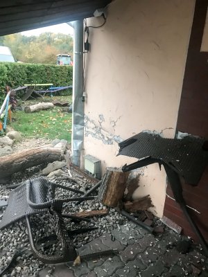 Zniszczone krzesła ogrodowe obok budynku mieszkalnego.