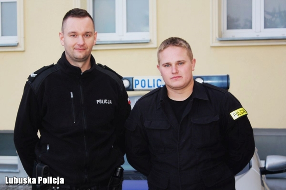 Policjanci stojący przed budynkiem komendy.