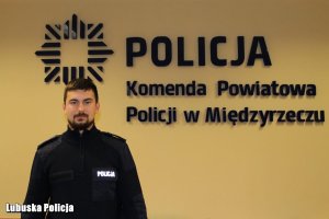 Policjant na tle ściany.