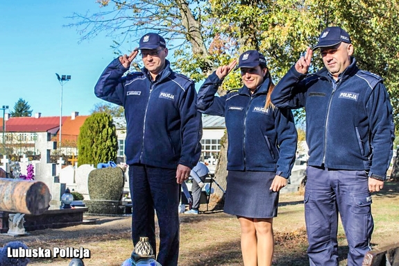 Policjantka i policjanci oddają hołd poległemu funkcjonariuszowi przy jego grobie