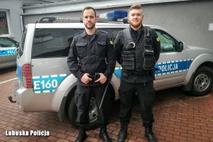 Policjanci na tle radiowozu