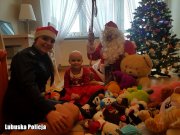 policjantka, dziewczynka i mężczyzna przebrany za świętego Mikołaja