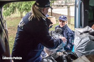 funkcjonariusze pakują worki do busa