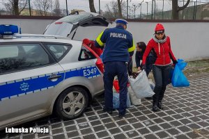 policjanci i sportowcy pakują paczki do radiowozu