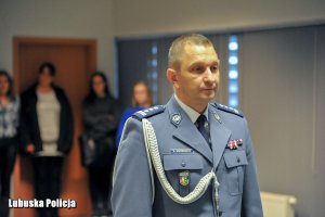 Policjant w umundurowaniu wyjściowym w sali konferencyjnej.