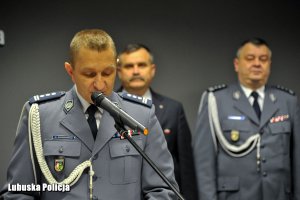 Przemawiający policjant, a z nim mężczyzna z innym policjantem.