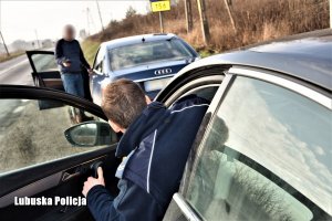 Policjant wychodzący z radiowozu do kontroli kierującego