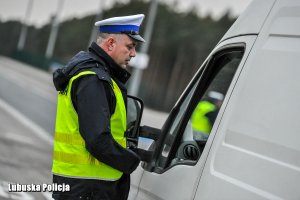 Policjant z urządzeniem do badania alkoholu w wydychanym powietrzu