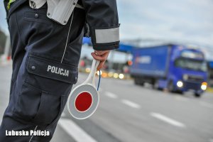 Policjant z tarczą do zatrzymywania pojazdów