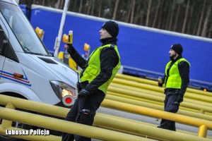 Policjanci z urządzeniem do badania trzeźwości przy samochodach