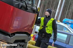 Policjant z urządzeniem do badania trzeźwości przy samochodzie