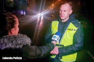 Policjant w kamizelce odblaskowej podczas wywiadu