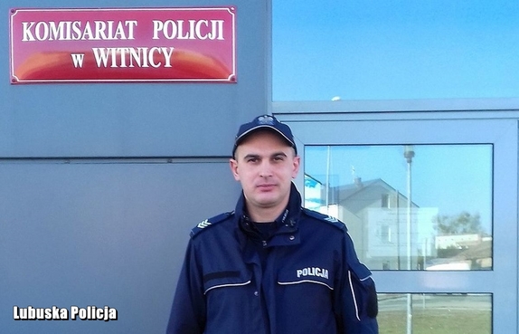 policjant stoi przed komendą