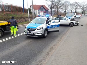 uszkodzony pojazd, radiowozy i policjanci