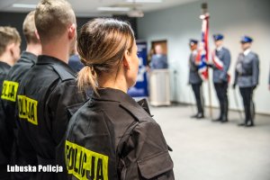 policjanci i poczet sztandarowy w tle