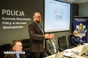 prelegenci, policjantka i przemawiający mężczyzna