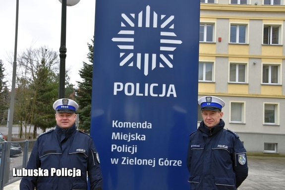 policjanci stoją przy banerze zielonogórskiej komendy