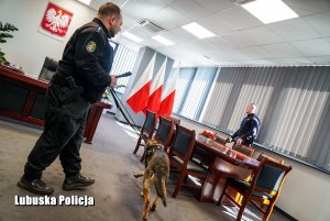 Sprawdzenie pirotechniczne w pomieszczeniu - policjanci z psem służbowym.