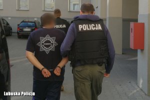 Nieumundurowany policjant z zatrzymanym mężczyzną.