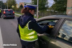 Policjantka kontroluje trzeźwość kierowcy.