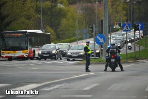 Policjant ruchu drogowego oraz na motocyklu na skrzyżowaniu zabezpieczając paradę