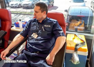 Policjant w krwiobusie przygotowany do oddania krwi