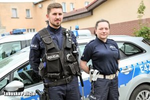 policjanci stoją przy radiowozie