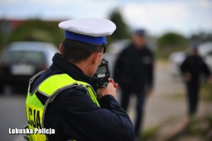 Policjant dokonuje kontroli prędkości pojazdów.