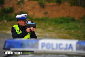 Policjant dokonuje kontroli prędkości pojazdów.