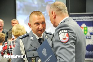 Inspektor Policji i dziękujący mu za służbę policjant